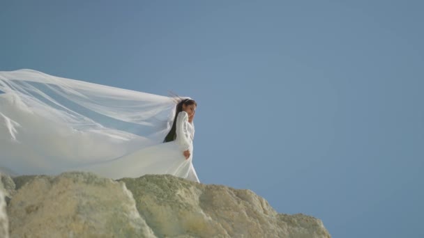 在高高的天空中 新娘的面纱在悬崖峭壁上迎风飘扬 象征着爱情的崇高境界 — 图库视频影像