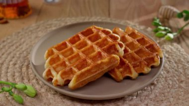 Üzerine pudra şekeri serpiştirilmiş Belçika waffle 'ı nefis bir sabah için tatlı bir davetiye sunar..