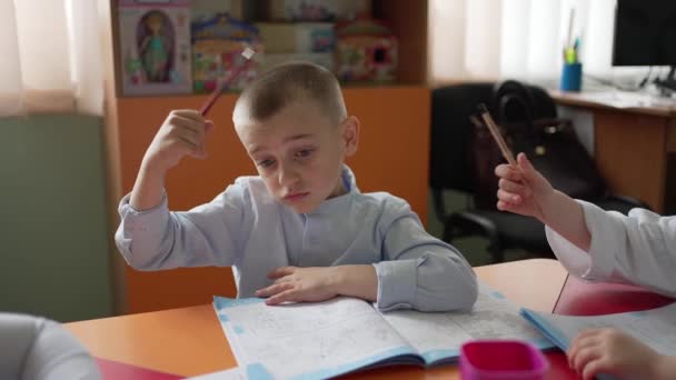 Klassrummet Med Ljusa Interiör Pojke Uniform Skjorta Tänker Hålla Penna — Stockvideo