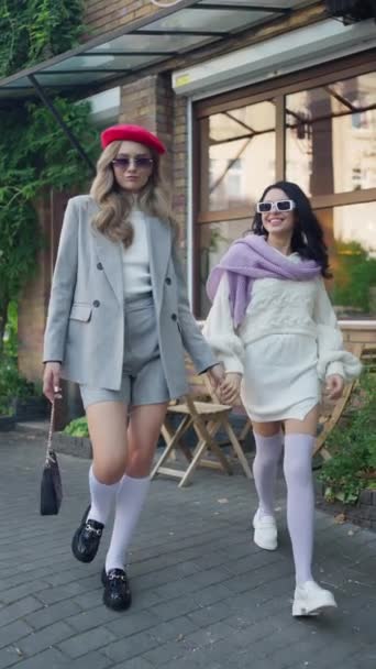 Två Kvinnliga Vänner Skrattar Klädda Attraktiva Höstkläder Medan Går — Stockvideo