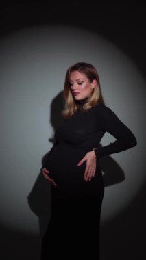 Müstakbel anne stüdyoda poz verirken karnını okşuyor..