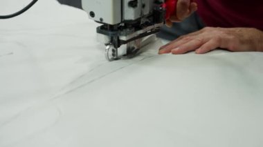 Dikiş fabrikasında kesme bıçağı kullanarak kumaş ürünlerini kestim..