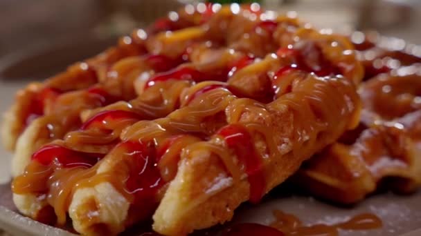 焦糖和覆盆子酱在甜甜的比利时华夫饼上编织精美的图案 — 图库视频影像