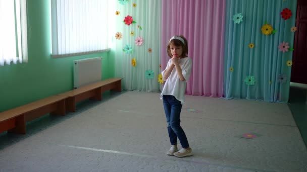 Παιδί Στέκεται Ευρύχωρη Αίθουσα Πολύχρωμες Κουρτίνες Και Χάρτινα Λουλούδια Στο — Αρχείο Βίντεο