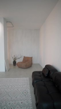 Modern oturma odasının içinde siyah bir kanepe var..