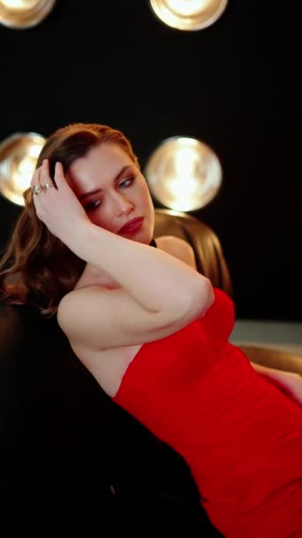 赤いドレスの女性が背中を伸ばし 彼女の手は優しく彼女の額に休む — ストック動画