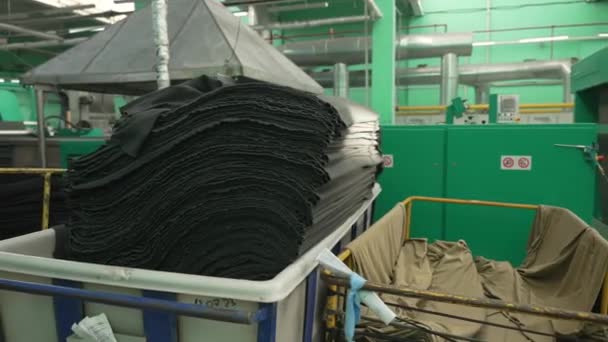 工业用纺织品处理 工厂中的堆装织物 装在垃圾桶里的成堆的黑色织物 为下一个生产阶段做好准备 — 图库视频影像