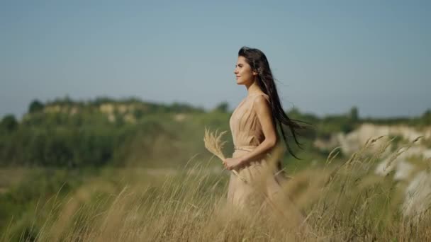 Kobieta Idzie Zamiarem Przez Łąkę Wzgórza Jej Beżowa Sukienka Włosy — Wideo stockowe
