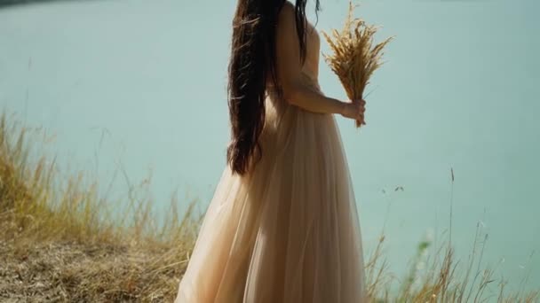 Açık Bej Elbiseli Kadın Elini Kaldırıyor Buğday Demetini Havada Tutuyor — Stok video
