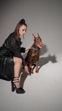 Köpeğe odaklanmış, tasma tutarak fotoğraf çekimine hazırlanıyor..