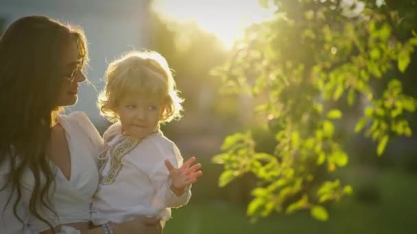 Mulher Sorridente Segura Criança Seus Braços Bosque Verde — Vídeo de Stock