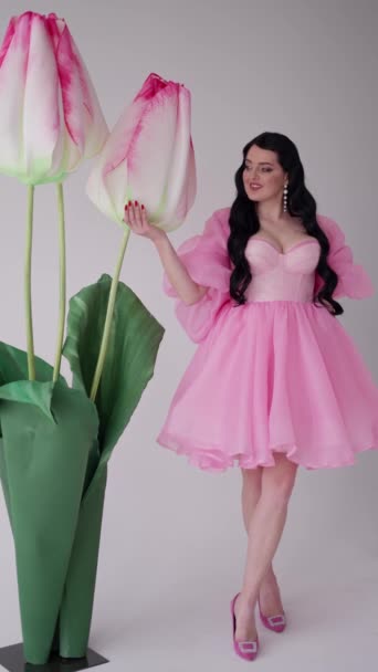 Młoda Kobieta Otwartym Dekoltem Sukience Koktajlowej Stoi Pobliżu Kwiatów — Wideo stockowe