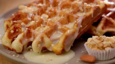 Belçika waffle 'ı beyaz çikolatayla kaplıdır. İnanılmaz bir desen için ince doğranmış fındıklı..