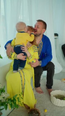 Ebeveynler yeni doğan bebeklerini şefkatle öper ve kucaklarlar. Mutlu, genç ebeveynler yeni doğan bebeklerine sarılıyorlar.