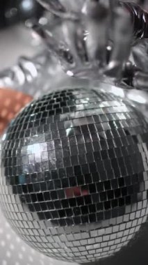 Gümüş eldivenli, seksi görünüşlü, disko topu tutan kadın elleri..