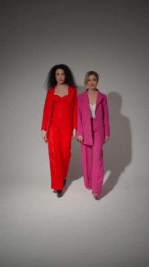 Parlak kostümlü kadınlar senkronize zarafet ve özgüvenle yürür..