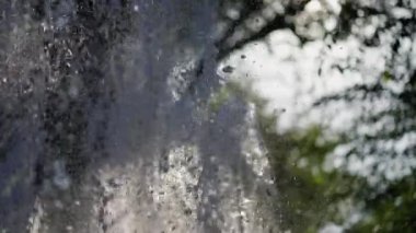 Büyük su sıçramaları hareketli dinamik ışıltılı bir resim oluşturur. Su damlaları güneşte parlar.