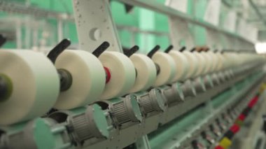 Tekstil Fabrikası 'nda Hassas İplik Dönüşü. Endüstriyel makinelere bağlanmış iplik makaraları..