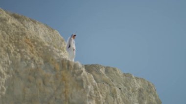 Düğün, gelin, beyazlar içinde, güneşli uçurumun tepesinden ufuk çizer.