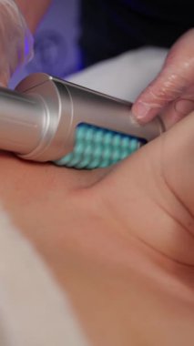 Özel bir cihaz kullanarak donanım masajının başarısı. Cihaz hastaların cildine dikkatle uygulanır.