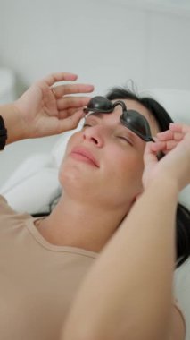Hasta koruyucu gözlük takıyor, kozmetik lazer işlemi sırasında güvenlik için gerekli..
