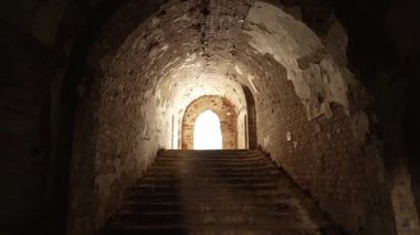 Büyüleyici bir fotoğraf merdiven çıkan tuğla kemer yolunu gösteriyor, sıcak ışıkta yıkanmış, gizem ve çürüme hissi veriyor..