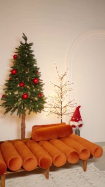Güzel dekore edilmiş Noel ağacı parlak kırmızı süsler ve parıldayan ışıklarla süslenmiş, sarılmış yeşil hediyeler, mumlarla çevrili..