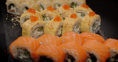 İçinde somon, susam tohumu ve turuncu yumurta bulunan çeşitli suşi dürümleri..