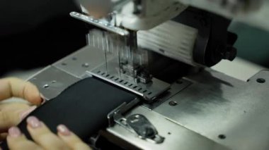 Endüstriyel dikiş makinesi, ağır siyah kumaş. Yoğun siyah maddeyle çalışan endüstriyel dikiş makinesinin mekanizması.