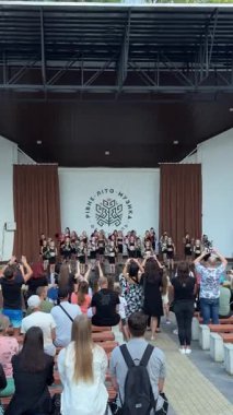 Bir çocuk dans grubu seyircilerin önünde sahnede dans ediyor..