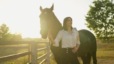 Gün batımında, bir binici ve atı güneşle vurgulanan, sessiz bir gücü paylaşıyor..