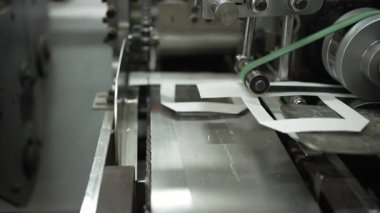 Modern baskı ya da ambalaj tesislerinde kağıt kesme, hassas üretim işlemleri ve endüstriyel makinelere yakın çekim.