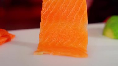 Beyaz tabakta taze çiğ somon parçası. Suşi rulosu malzemesi.