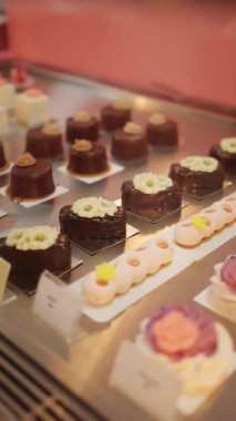 Çikolatalı kremalı pasta, gurme tatlılar ve bir kafede sanatsal dekor içeren şekerleme vitrini..