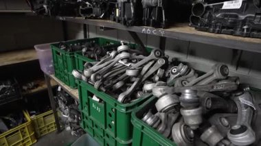 Kutulardaki metal araba süspansiyon kolları, raflardaki bir depoda araba parçaları depolamak..