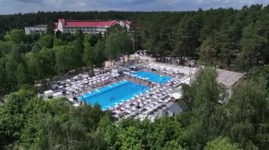 Yüzme havuzlu bir tatil köyünün havadan görünüşü, ormanla çevrili, lüks bir otelde yaz tatili yeri..