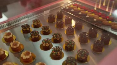 Çeşitli çikolatalı mousse kekleri ve ekleriyle fırın vitrininde nefis şekerlemeler sunan gurme pastane..