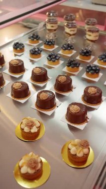 Çikolatalı mus kekleri ve yaban mersinli turtalar ile hamur işi vitrininde zarif tatlı dükkanları seçimi..