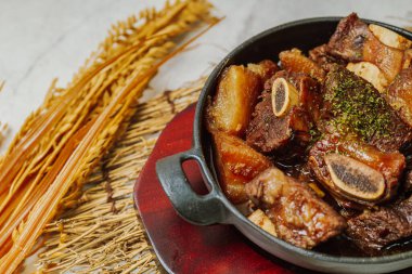 Biftek kısa kaburga, yağlı, tatlı soya soslu ve havuç, kestane, ginko fındığı ve diğer sebzelerle sulanana kadar kavurulmuş..