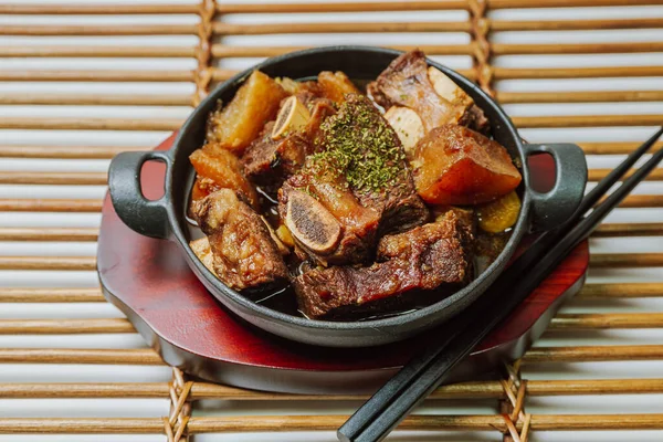 galbijjim, Korean Braised Short Ribs : Beef short ribs, trimmed of fat, seasoned in sweet soy sauce, and braised until tender with carrots, chestnuts, ginko nuts, and other vegetables.