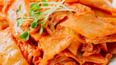 Yağla yağlanmış tavada doğranmış yeşil soğan ve sarımsaklı mayalanmış kimchi, genellikle pirinçle yenen popüler bir mezedir. Soya peyniri ile de iyi gider..