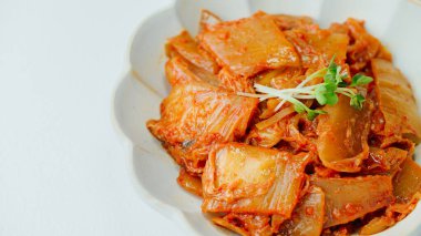 Yağla yağlanmış tavada doğranmış yeşil soğan ve sarımsaklı mayalanmış kimchi, genellikle pirinçle yenen popüler bir mezedir. Soya peyniri ile de iyi gider..