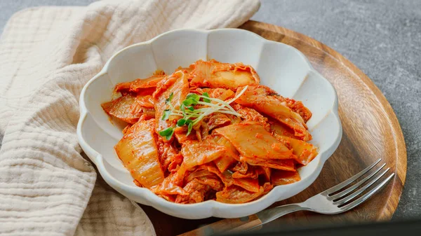 Yağla yağlanmış tavada doğranmış yeşil soğan ve sarımsaklı mayalanmış kimchi, genellikle pirinçle yenen popüler bir mezedir. Soya peyniri ile de iyi gider..