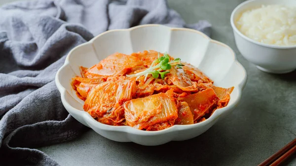 Yağla yağlanmış tavada doğranmış yeşil soğan ve sarımsaklı mayalanmış kimchi, genellikle pirinçle yenen popüler bir mezedir. Soya peyniri ile de iyi gider..