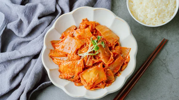 Yağla yağlanmış tavada doğranmış yeşil soğan ve sarımsaklı mayalanmış kimchi, genellikle pirinçle yenen popüler bir mezedir. Soya peyniri ile de iyi gider..