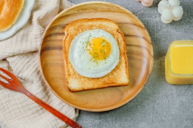 Tahta tabakta kızarmış yumurta ve kızarmış ekmek.