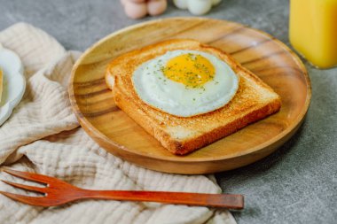Tahta tabakta kızarmış yumurta ve kızarmış ekmek.