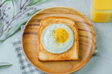 Tahta tabakta kızarmış yumurta ve kızarmış ekmek.