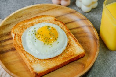 Tahta tabakta kızarmış yumurta ve kızarmış ekmek.