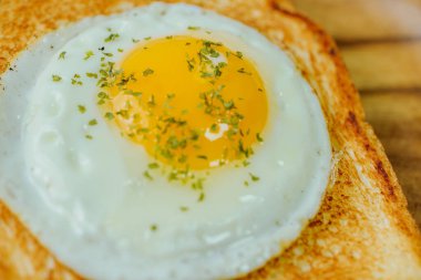 Tahta tabakta kızarmış yumurta ve kızarmış ekmek.